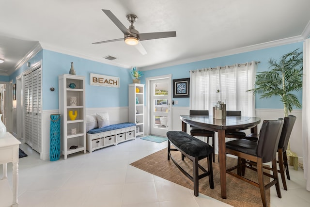 dining area with crown molding, ceiling fan, and light tile patterned floors