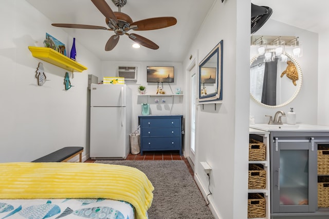 tiled bedroom with ceiling fan, white fridge, sink, and a wall unit AC