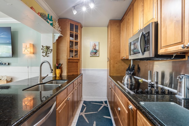 kitchen with backsplash, appliances with stainless steel finishes, sink, and dark stone counters