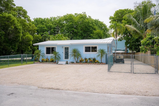 768 Musa Dr, Key Largo, FL 33037 - view of front of house with a gate, driveway, stucco siding, and a metal roof