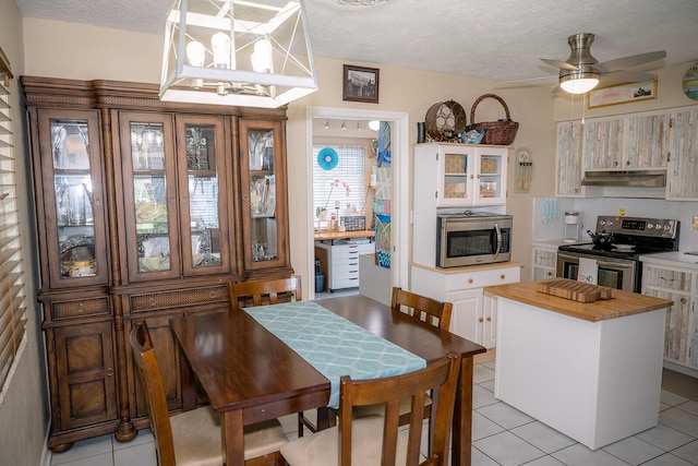 768 Musa Dr, Key Largo, FL 33037 - dining area with light tile patterned flooring, ceiling fan, and a textured ceiling