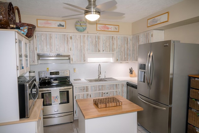 768 Musa Dr, Key Largo, FL 33037 - kitchen featuring stainless steel appliances, wooden counters, under cabinet range hood, ceiling fan, and a center island