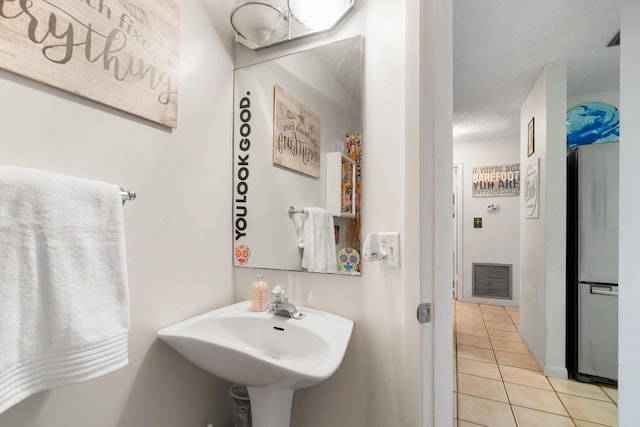 bathroom featuring sink, tile patterned floors, and a textured ceiling