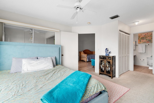 carpeted bedroom featuring a textured ceiling, ensuite bath, a closet, and ceiling fan