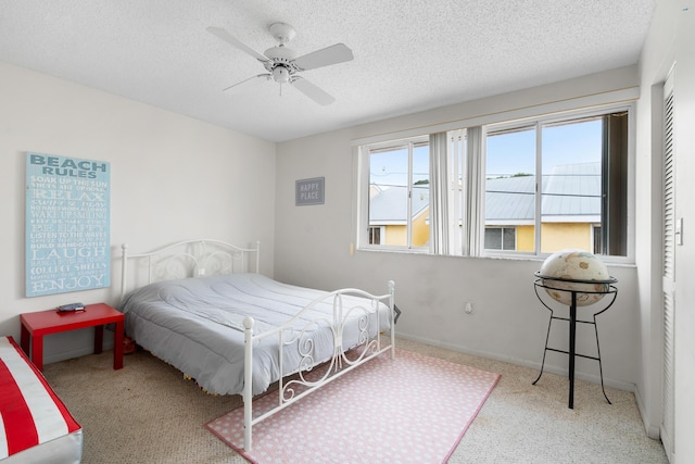 carpeted bedroom with ceiling fan and a textured ceiling