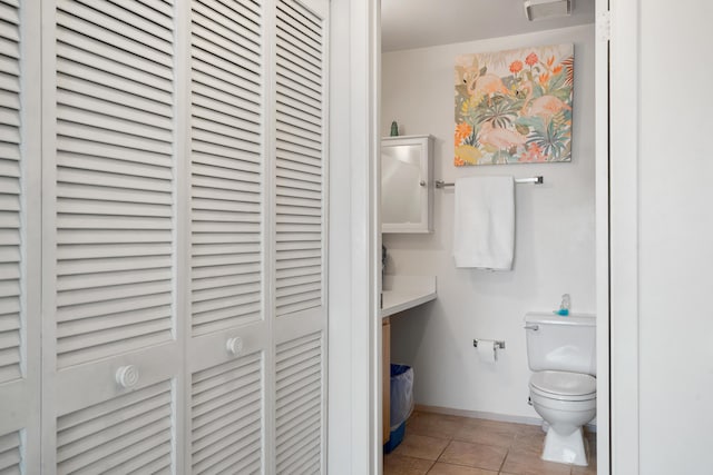 bathroom featuring visible vents, baseboards, toilet, tile patterned flooring, and a closet