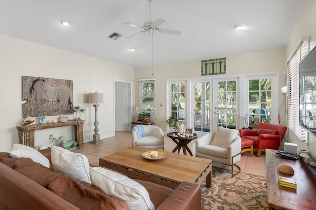 living room featuring lofted ceiling, light tile patterned flooring, visible vents, a ceiling fan, and french doors