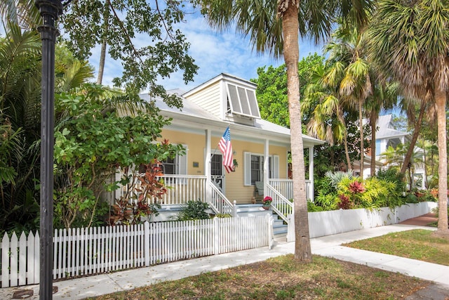 bungalow-style home featuring covered porch and a fenced front yard