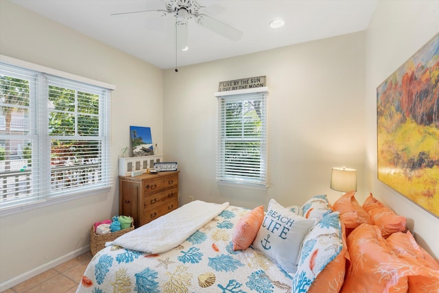 bedroom with ceiling fan, baseboards, and light tile patterned floors