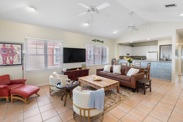 living area featuring light tile patterned floors, baseboards, visible vents, a ceiling fan, and high vaulted ceiling