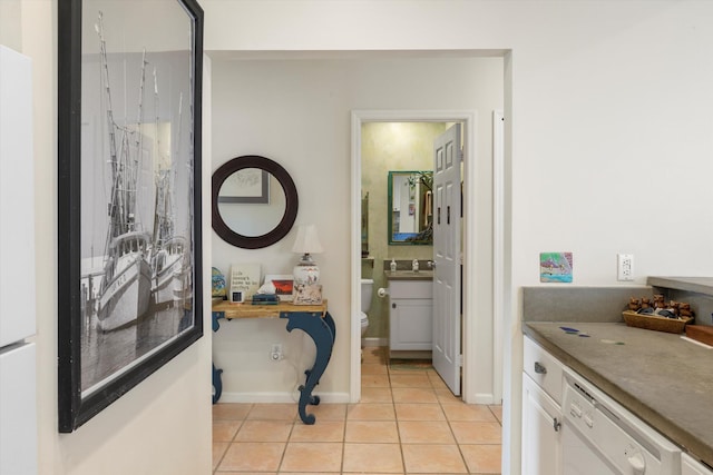 corridor with light tile patterned flooring and baseboards