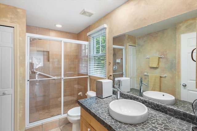 bathroom featuring visible vents, toilet, vanity, a shower stall, and a closet