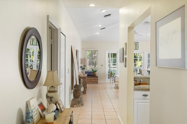 corridor featuring recessed lighting, visible vents, vaulted ceiling, and light tile patterned floors