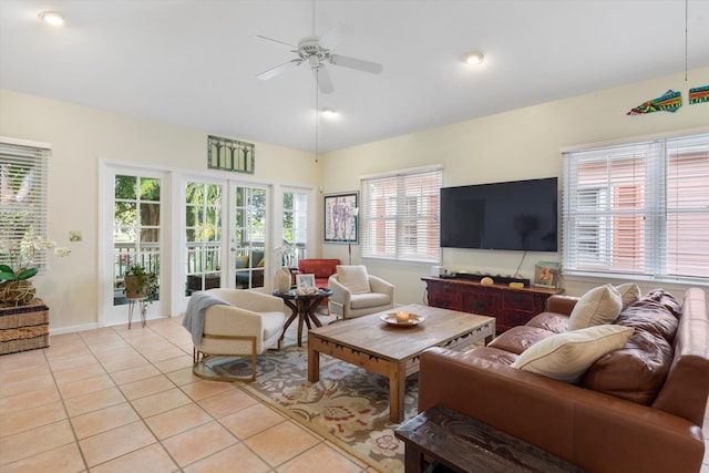 living area with light tile patterned floors, vaulted ceiling, a ceiling fan, and french doors