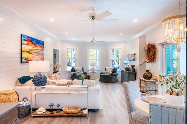 living room with ornamental molding, a chandelier, and light hardwood / wood-style floors