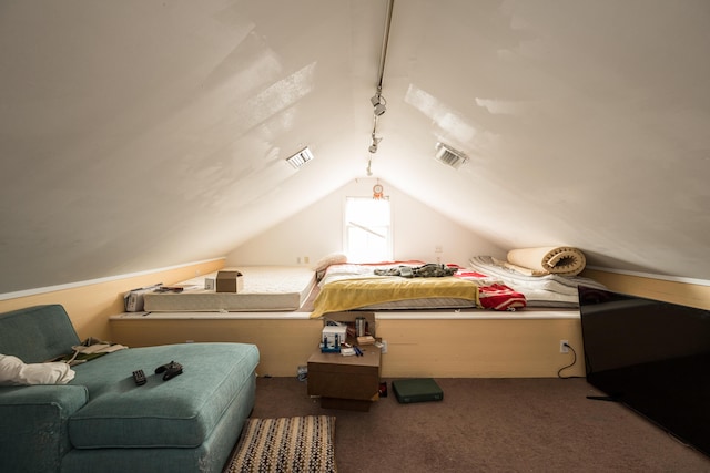 bedroom with dark colored carpet, lofted ceiling, and track lighting