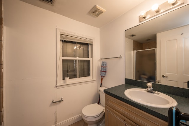 bathroom with vanity, toilet, and a shower with shower door