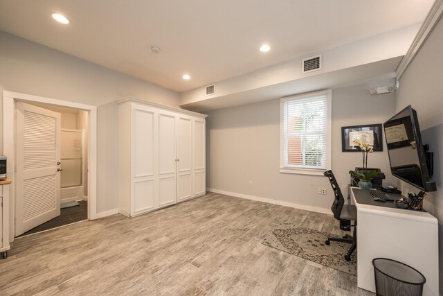 home office with light hardwood / wood-style flooring