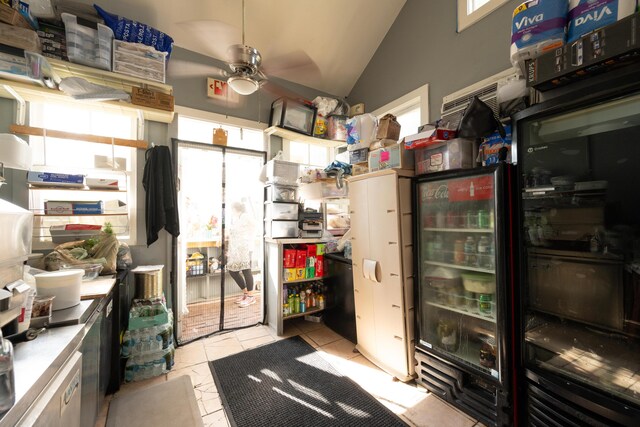 interior space featuring lofted ceiling, plenty of natural light, ceiling fan, and light tile patterned flooring