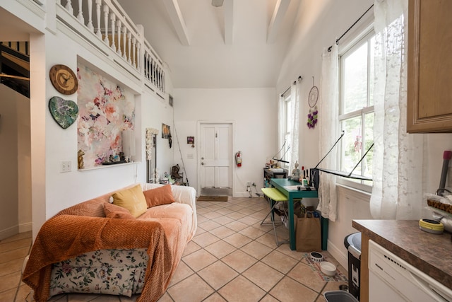 tiled living room featuring beamed ceiling and a high ceiling