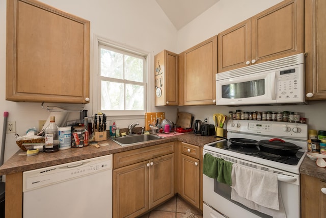 kitchen with vaulted ceiling, white appliances, sink, and light tile patterned floors