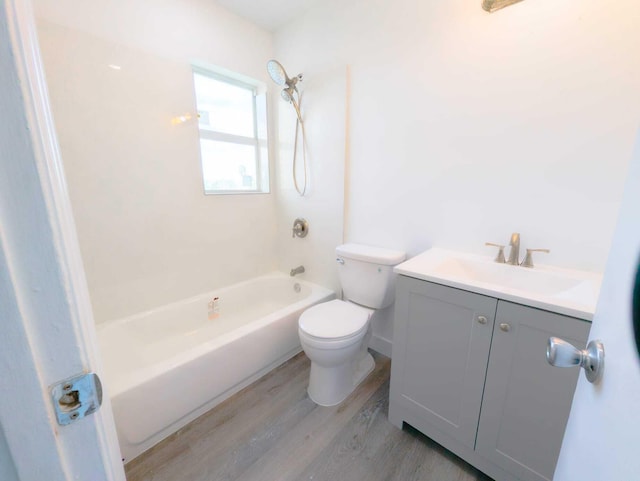 full bathroom with hardwood / wood-style flooring, vanity,  shower combination, and toilet