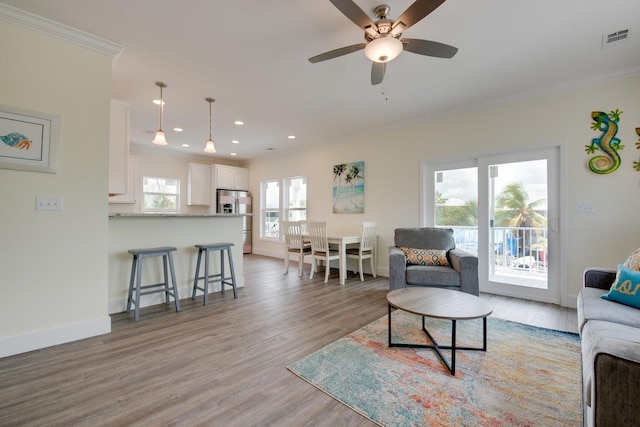 living room with ornamental molding, ceiling fan, and light hardwood / wood-style floors