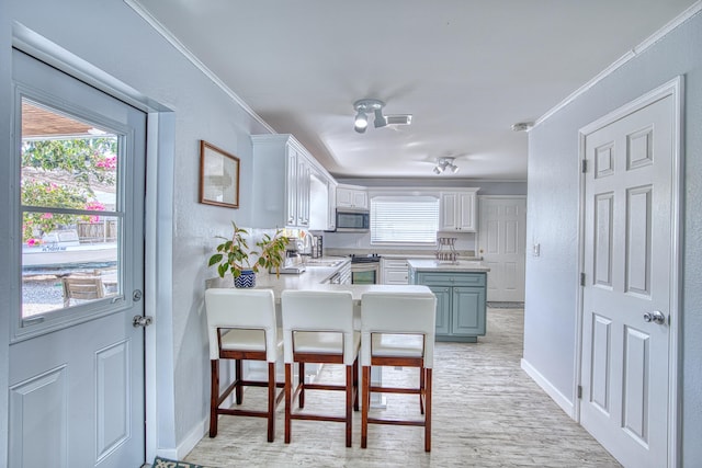 136 1st Rd, Key Largo, FL 33037 - kitchen with appliances with stainless steel finishes, ornamental molding, white cabinetry, baseboards, and light countertops