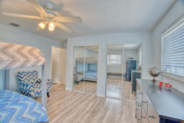 136 1st Rd, Key Largo, FL 33037 - bedroom featuring two closets, multiple windows, light wood-style floors, and a ceiling fan