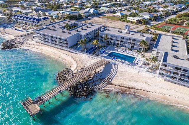 birds eye view of property with a water view and a beach view