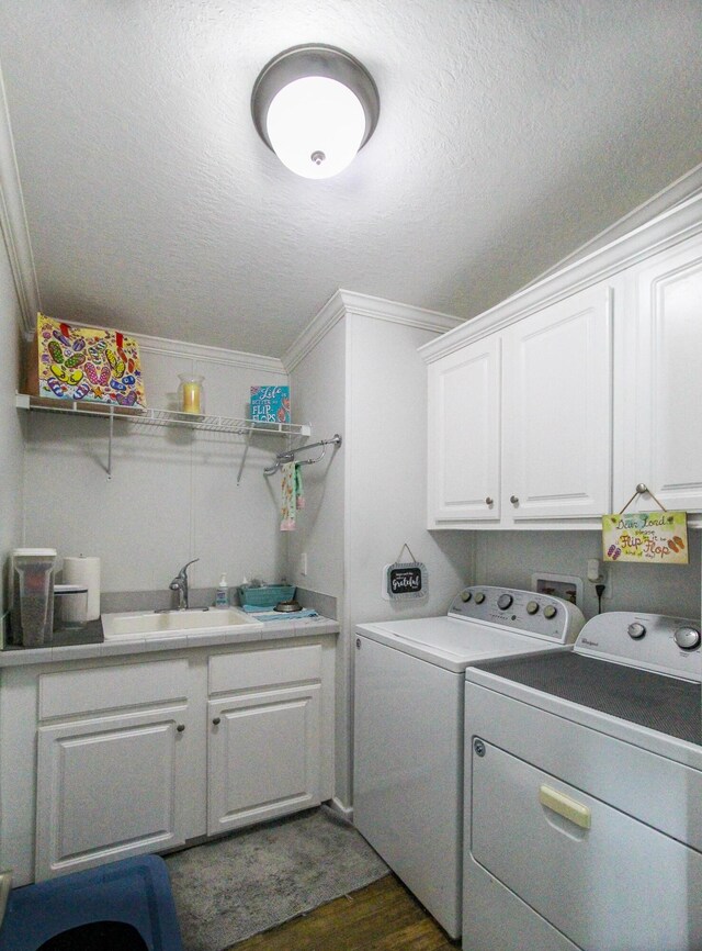 laundry area featuring dark wood-style floors, crown molding, cabinet space, a textured ceiling, and independent washer and dryer