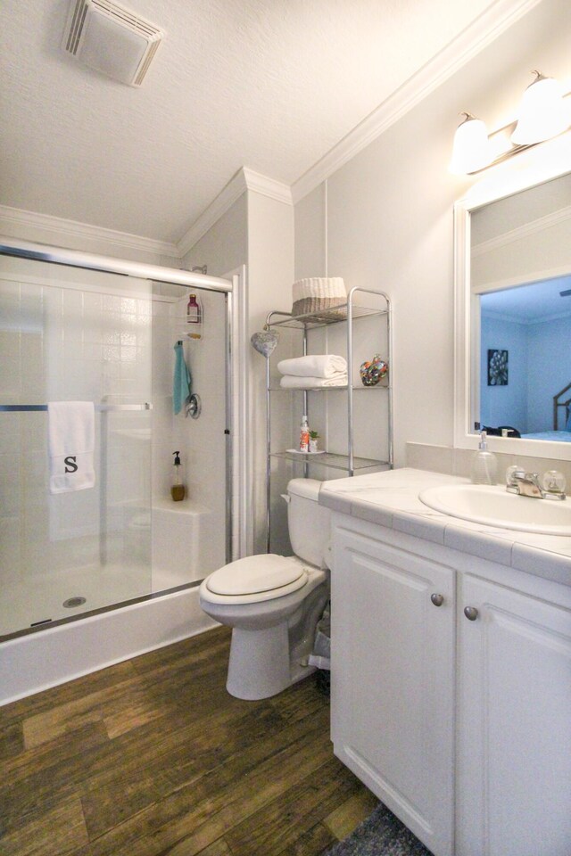 full bathroom featuring crown molding, visible vents, a stall shower, vanity, and wood finished floors