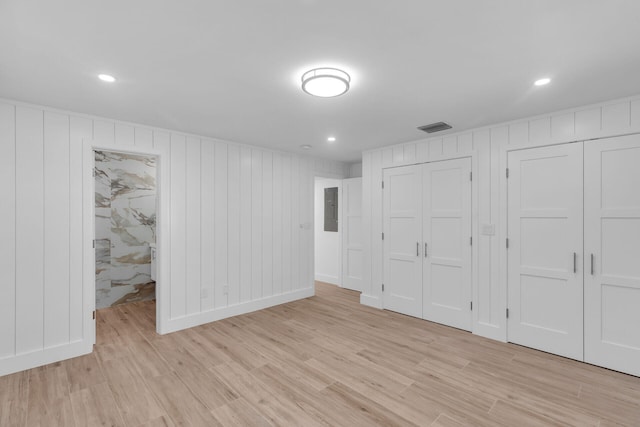 basement with electric panel and light wood-type flooring