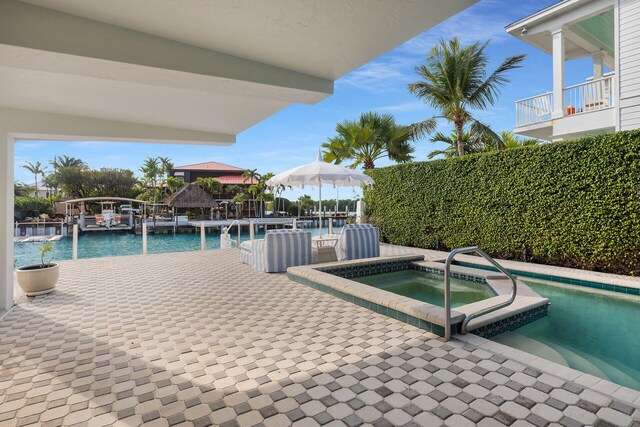 view of pool with a water view and an in ground hot tub