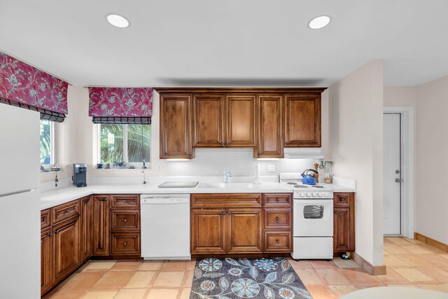 kitchen featuring tasteful backsplash, sink, and white appliances