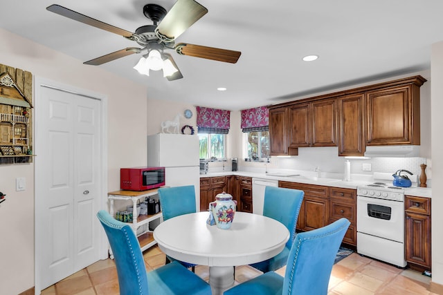 kitchen featuring light tile patterned flooring, sink, backsplash, ceiling fan, and white appliances