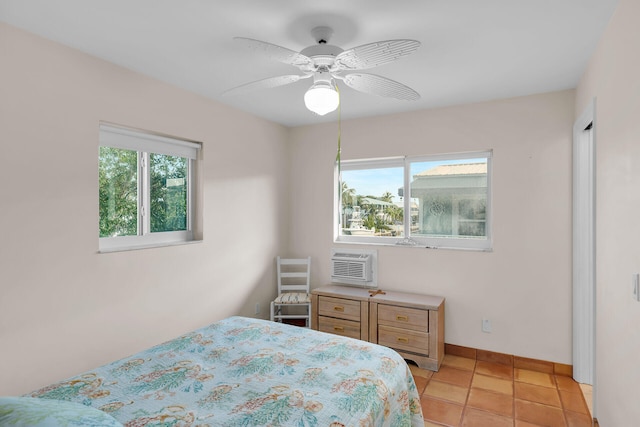 tiled bedroom with ceiling fan and an AC wall unit