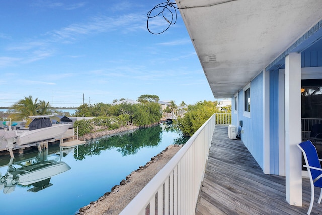 balcony with a water view and a dock