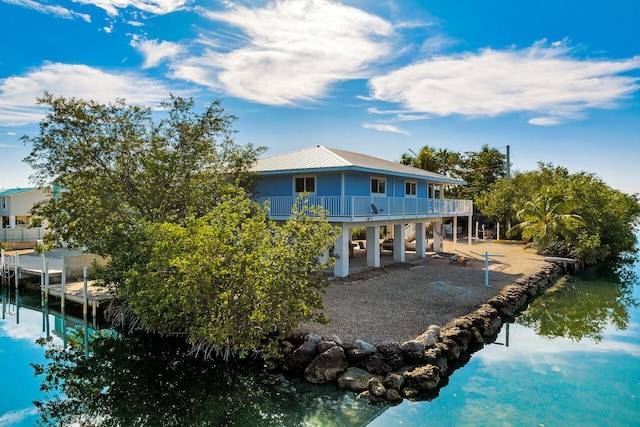 back of property featuring a balcony and a water view