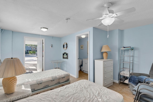 bedroom featuring ceiling fan, a textured ceiling, and ensuite bathroom