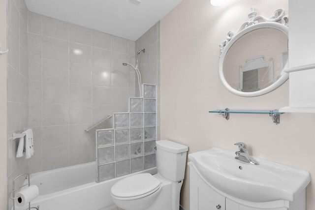 full bathroom featuring vanity, tiled shower / bath, and toilet