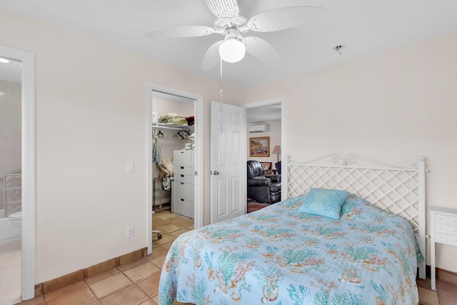 bedroom featuring light tile patterned floors, ceiling fan, a wall unit AC, a walk in closet, and a closet