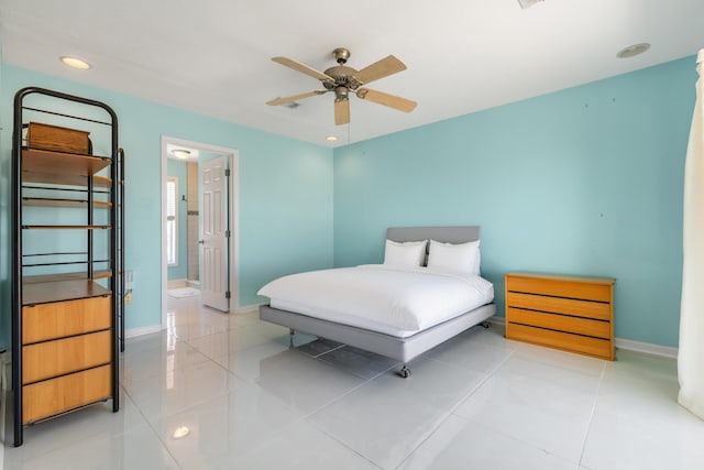 bedroom featuring connected bathroom, baseboards, and light tile patterned flooring