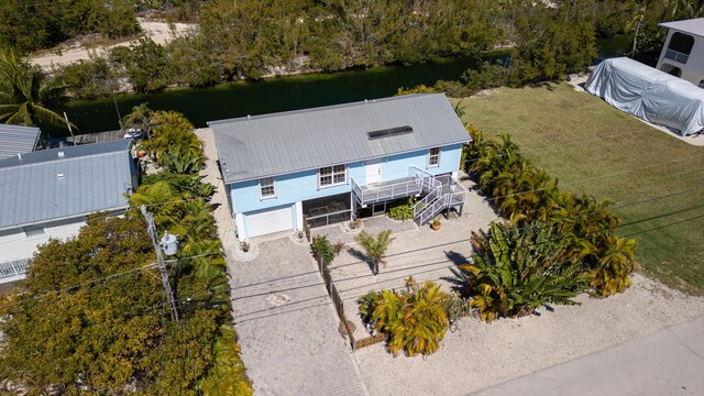 back of property featuring stairway, metal roof, and a sunroom