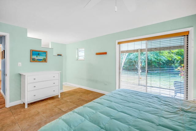 tiled bedroom featuring ceiling fan and multiple windows