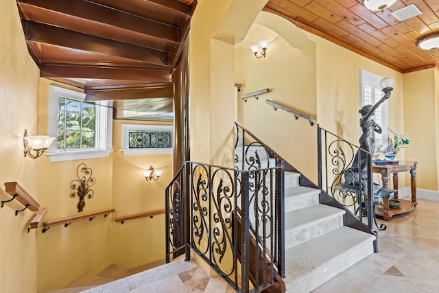 stairs featuring crown molding and wooden ceiling