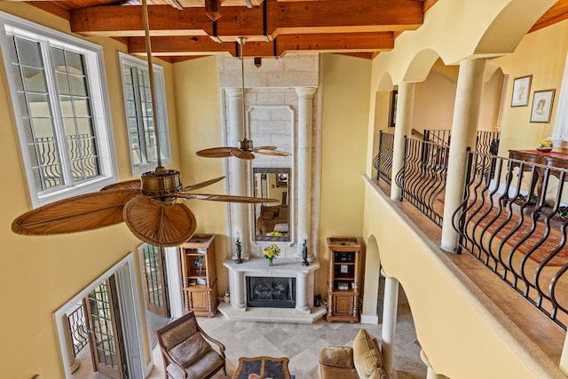 hallway with beamed ceiling, carpet flooring, and ornate columns