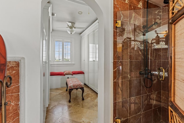 bathroom featuring ceiling fan and a shower with shower door