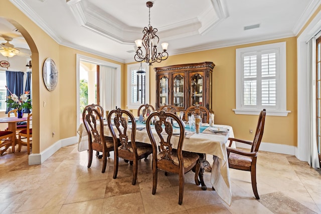 dining space with crown molding, a wealth of natural light, and a tray ceiling