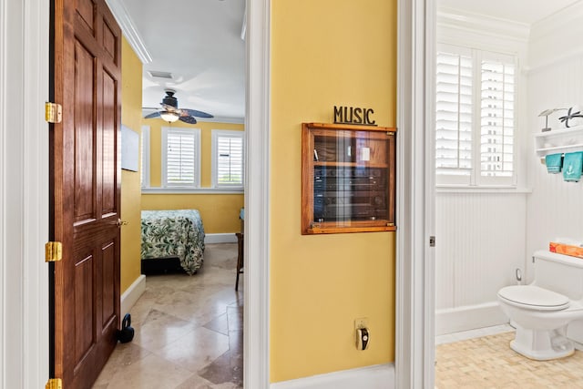 bathroom with ceiling fan, ornamental molding, and toilet